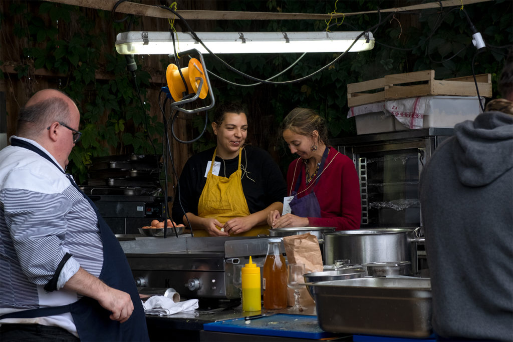 two female chefs preparing food in the kitchen, one is smiling