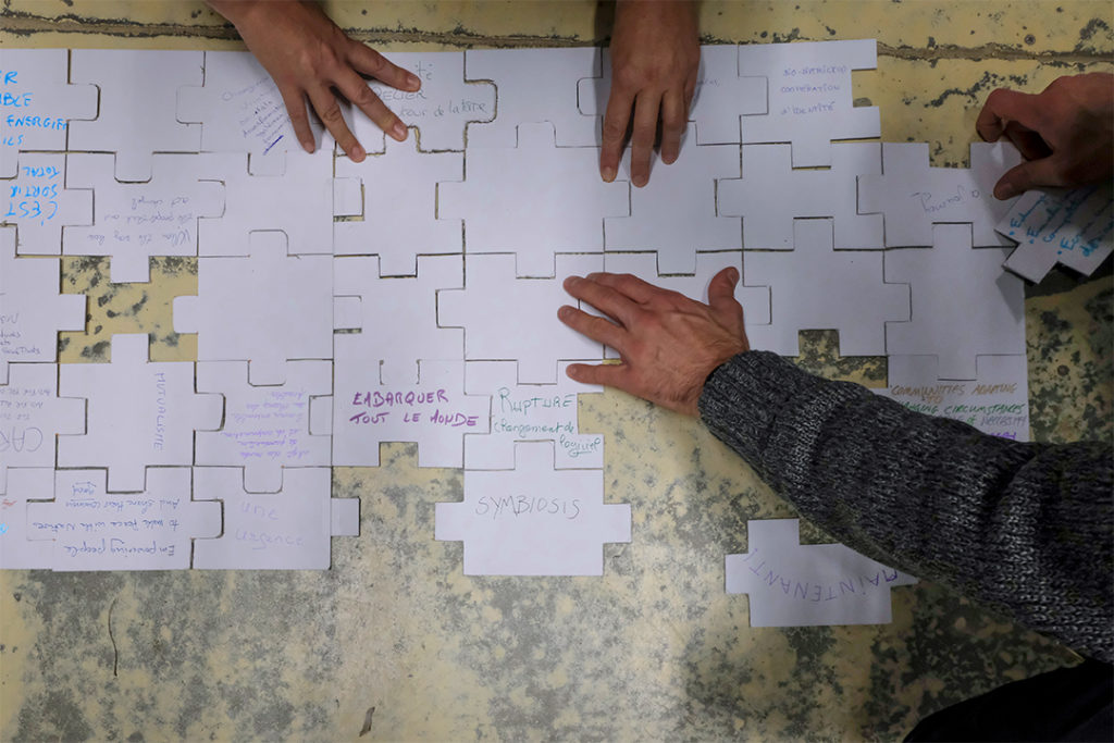 hands working on the puzzle, from close up can see some words