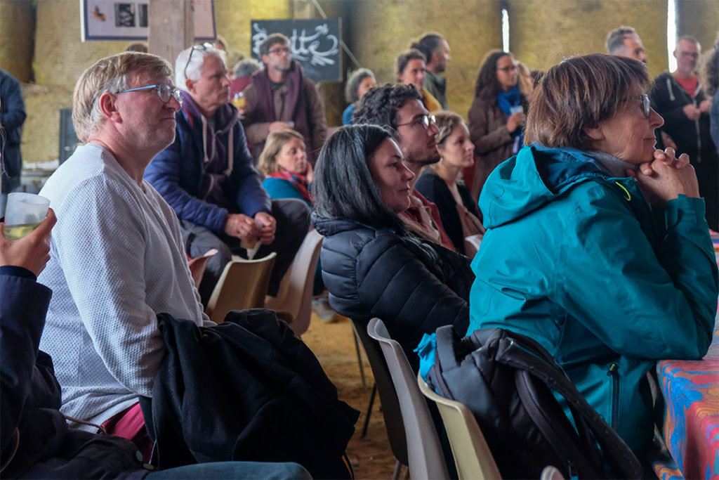Audience listening to panel close up, mixed age groups, hay bales in background
